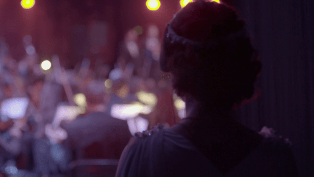 the-singer-looks-at-the-orchestra-from-behind-the-scenes-before-going-on-stage_hwjy8pfl__F0000